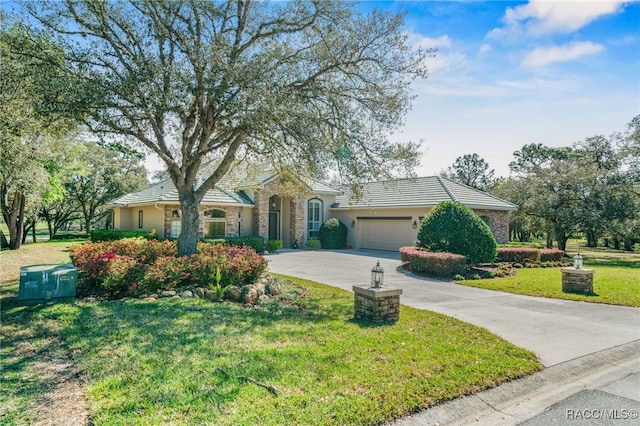 ranch-style home with a garage, stucco siding, a front lawn, and a tiled roof