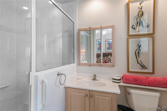 bathroom with vanity, toilet, and a shower stall