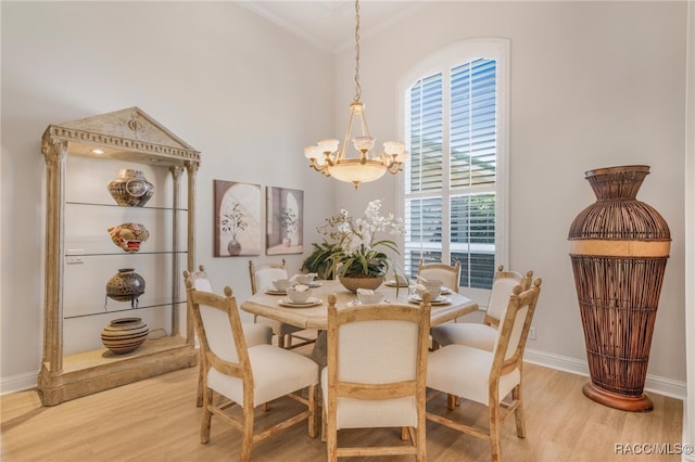 dining room with baseboards, light wood-style floors, an inviting chandelier, and ornamental molding