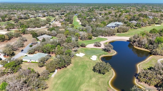 drone / aerial view with a water view, a view of trees, and view of golf course