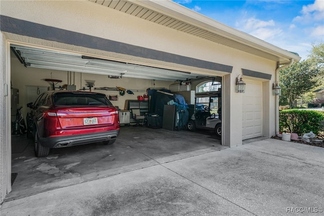 garage featuring concrete driveway and a garage door opener