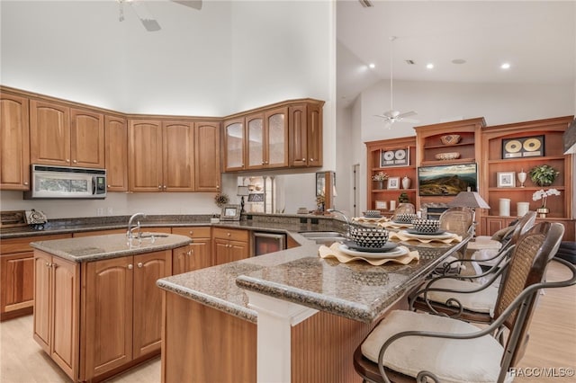 kitchen with a kitchen island with sink, ceiling fan, and a sink