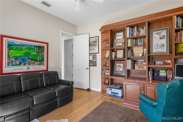 living area featuring visible vents, light wood-type flooring, and a ceiling fan