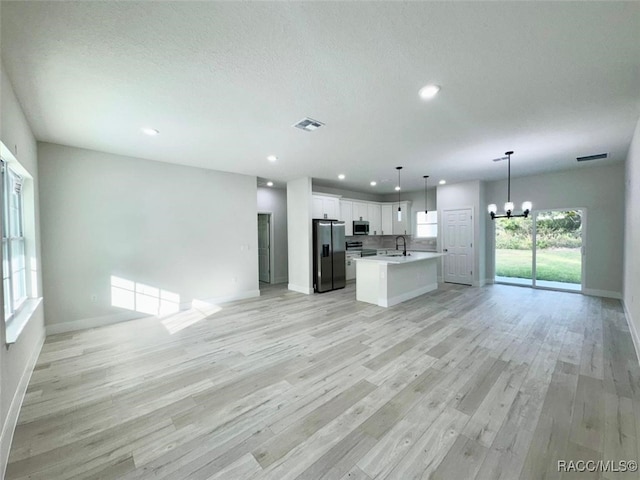 kitchen with sink, light hardwood / wood-style floors, pendant lighting, white cabinets, and appliances with stainless steel finishes