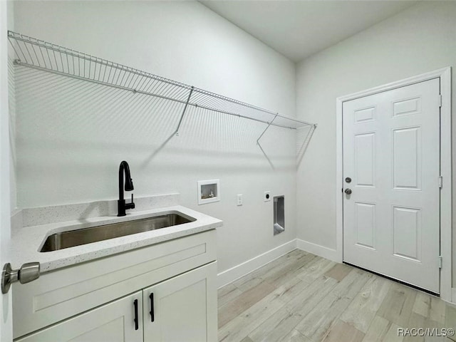 laundry area featuring cabinets, sink, hookup for a washing machine, light hardwood / wood-style flooring, and hookup for an electric dryer