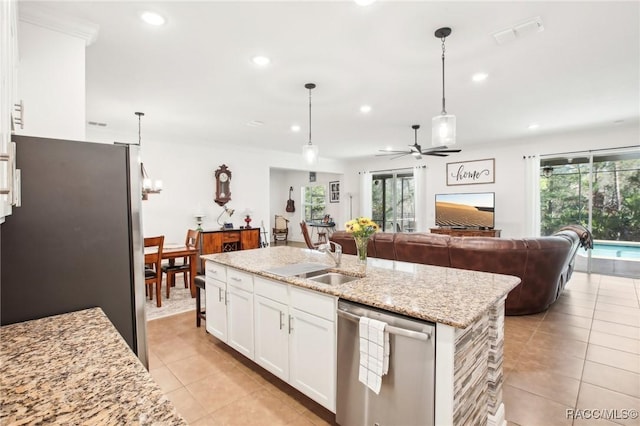 kitchen featuring appliances with stainless steel finishes, pendant lighting, white cabinets, ceiling fan, and a center island with sink