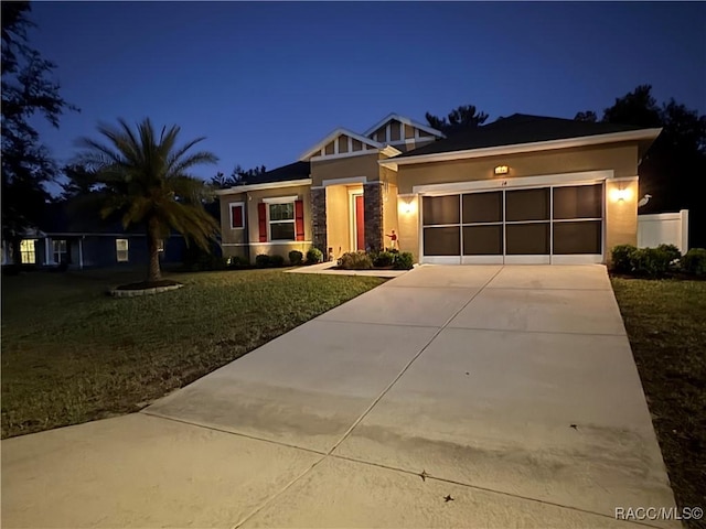 view of front of property featuring a garage and a lawn