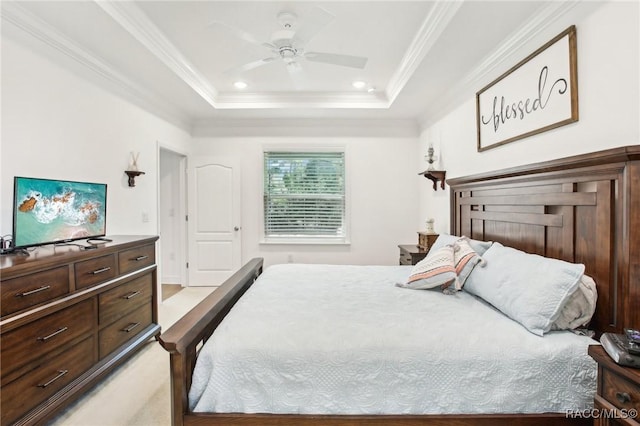 bedroom with ornamental molding, ceiling fan, and a tray ceiling