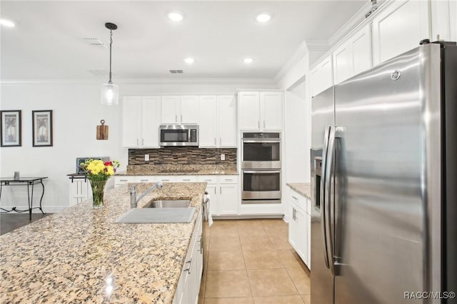 kitchen with hanging light fixtures, appliances with stainless steel finishes, sink, and white cabinets