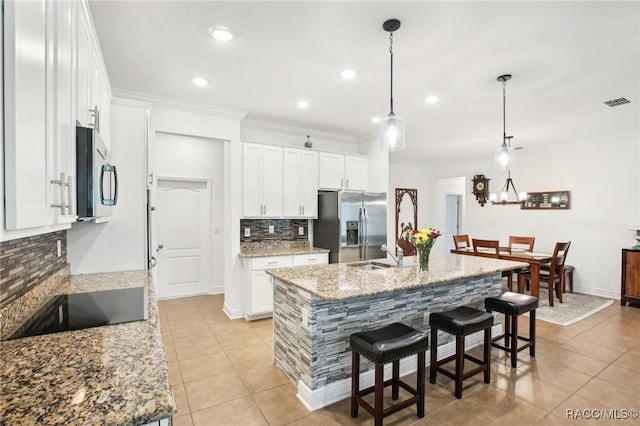 kitchen featuring white cabinetry, stainless steel appliances, and a kitchen island with sink