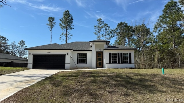 view of front of property featuring a garage, stucco siding, concrete driveway, and a front yard