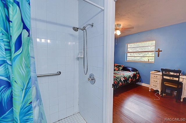 bathroom featuring a shower with shower curtain, ceiling fan, wood-type flooring, and a textured ceiling