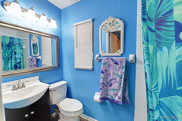 bathroom featuring a shower with curtain, vanity, and toilet