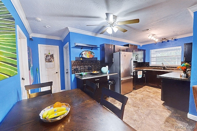 dining area with a textured ceiling, ceiling fan, sink, and crown molding