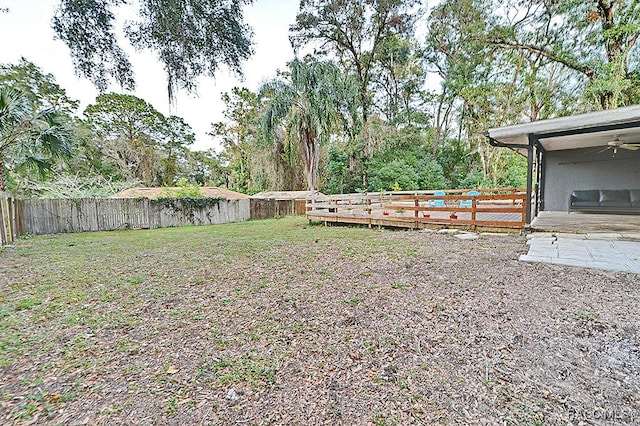 view of yard with ceiling fan and a wooden deck