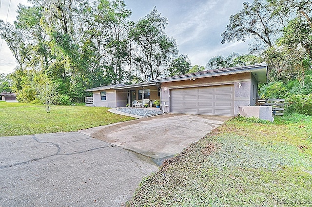 single story home featuring a garage and a front lawn