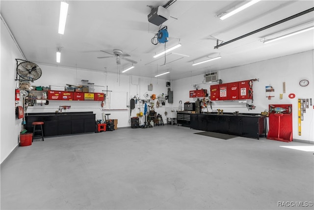 garage featuring a workshop area, ceiling fan, electric panel, and a garage door opener