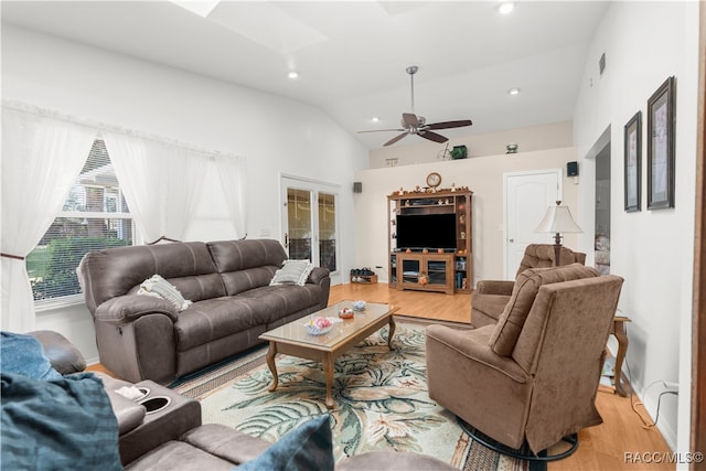 living room featuring ceiling fan, light hardwood / wood-style floors, and vaulted ceiling