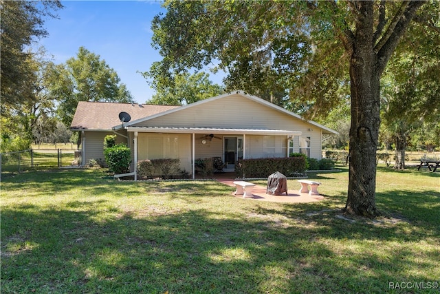 rear view of property with a patio area, ceiling fan, and a yard