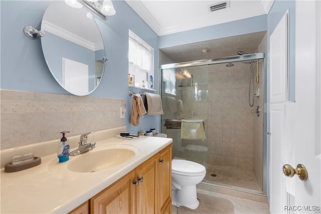 bathroom with vanity, toilet, a shower with shower door, and crown molding