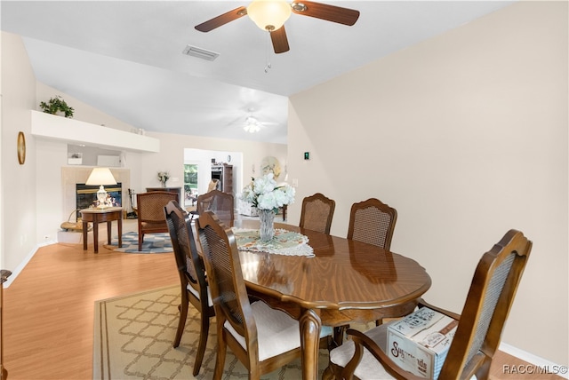 dining room featuring ceiling fan, vaulted ceiling, and light hardwood / wood-style flooring