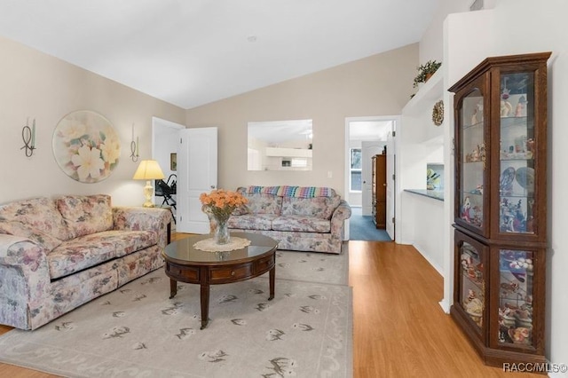 living room with light hardwood / wood-style flooring and lofted ceiling