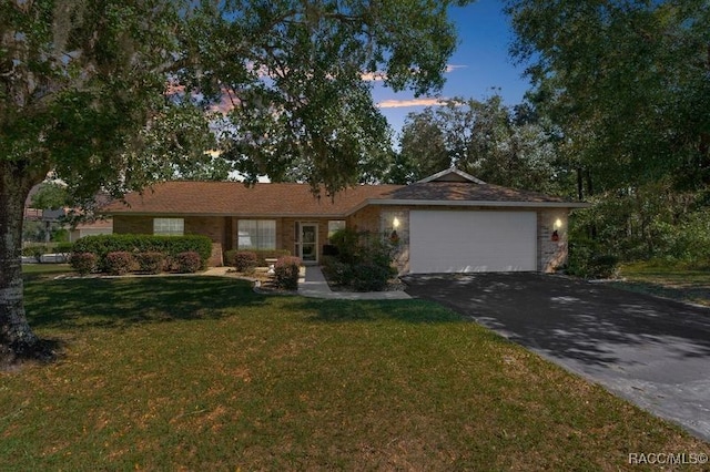 single story home with a lawn and a garage