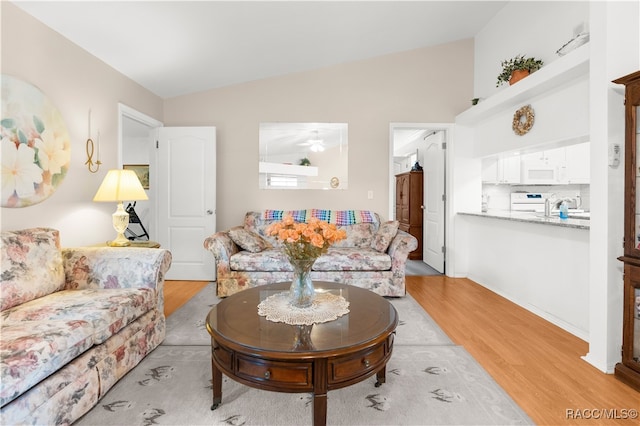 living room featuring vaulted ceiling and light hardwood / wood-style flooring