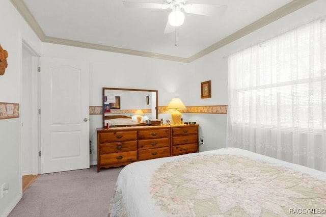 carpeted bedroom featuring ceiling fan and crown molding