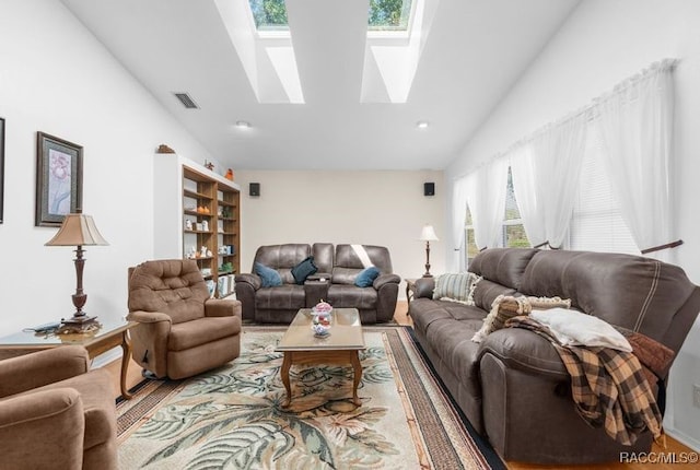 living room with vaulted ceiling with skylight