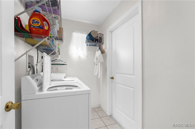 washroom featuring washer and clothes dryer and light tile patterned floors