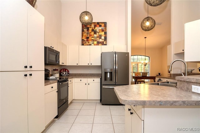 kitchen with pendant lighting, a high ceiling, black appliances, light tile patterned flooring, and kitchen peninsula