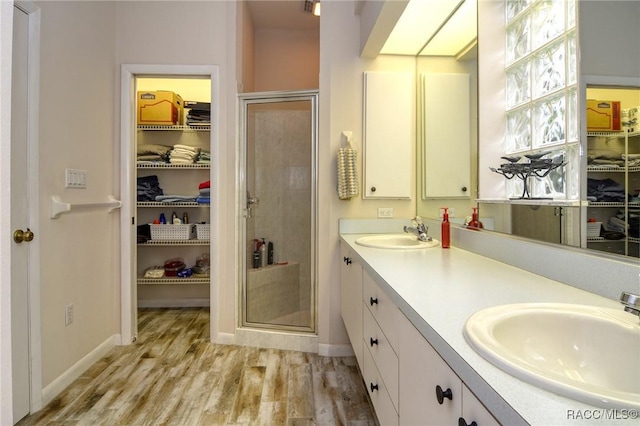 bathroom with vanity, a shower with shower door, and hardwood / wood-style flooring