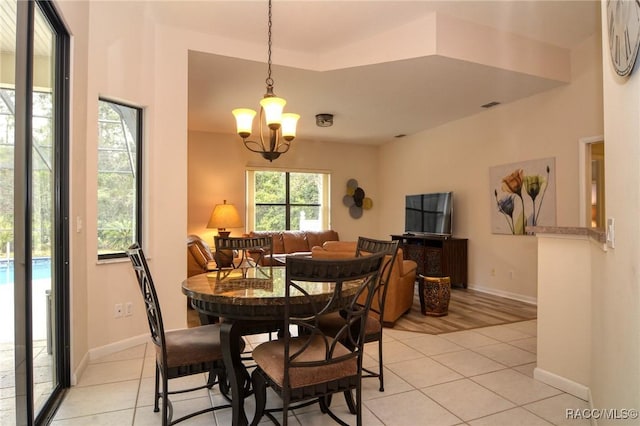 tiled dining room with a notable chandelier