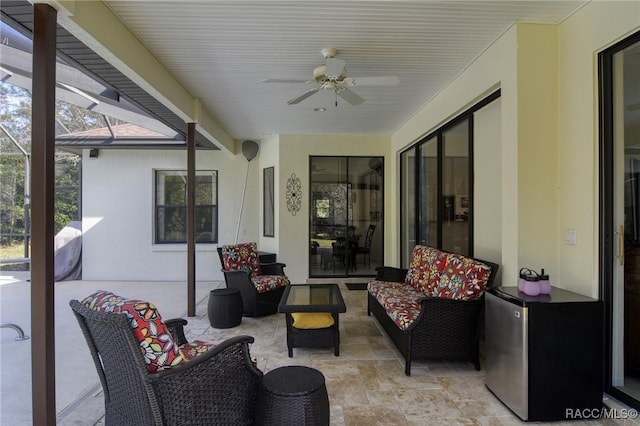 view of patio with an outdoor hangout area, glass enclosure, and ceiling fan