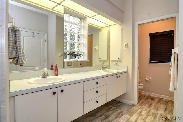 bathroom with hardwood / wood-style flooring, vanity, and toilet