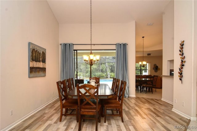 dining room featuring light wood-type flooring and a chandelier