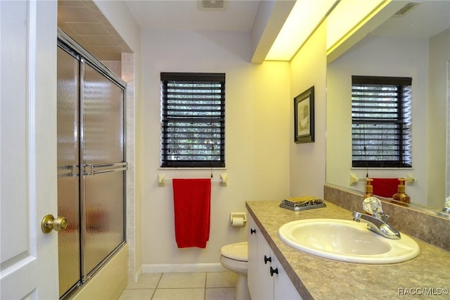 full bathroom with tile patterned flooring, vanity, bath / shower combo with glass door, and toilet