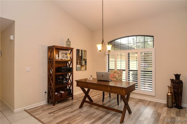 home office featuring light hardwood / wood-style floors, vaulted ceiling, and a notable chandelier