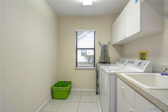 laundry room featuring washer and clothes dryer, cabinets, light tile patterned floors, and sink