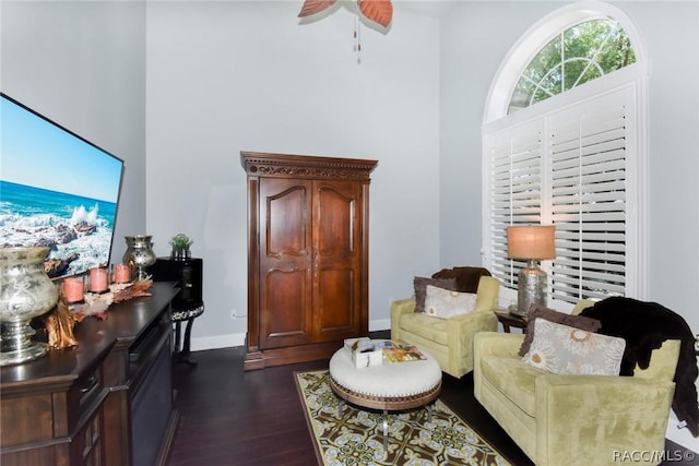 living room featuring dark wood-type flooring and ceiling fan