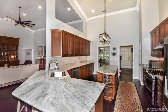 kitchen with sink, a center island, high vaulted ceiling, hanging light fixtures, and stainless steel appliances