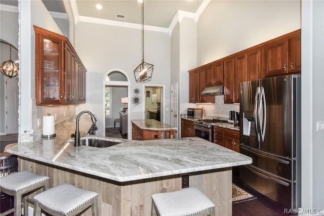 kitchen with sink, a center island, a kitchen breakfast bar, kitchen peninsula, and stainless steel appliances