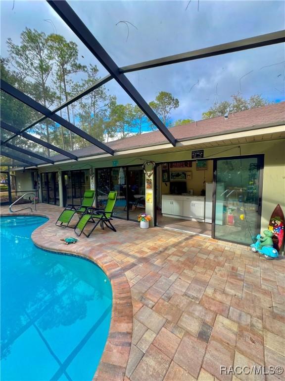 view of swimming pool with a lanai and a patio