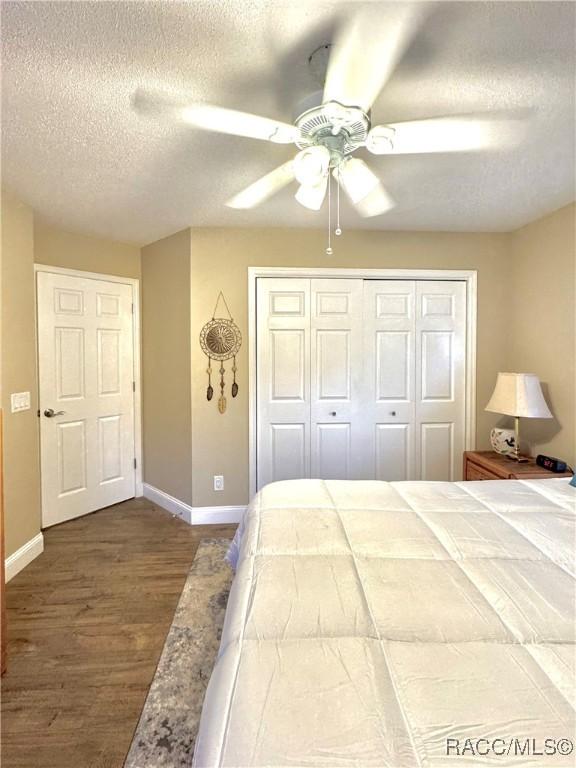 bedroom featuring a textured ceiling, ceiling fan, a closet, and hardwood / wood-style floors