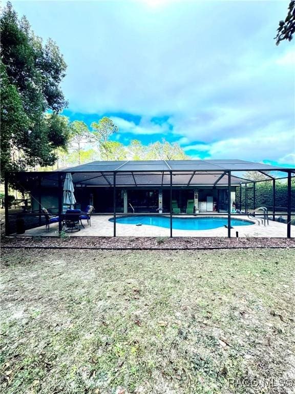 view of swimming pool with a patio and glass enclosure