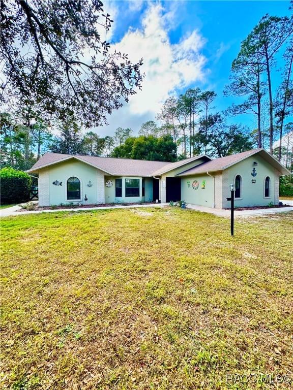 ranch-style home with a front lawn