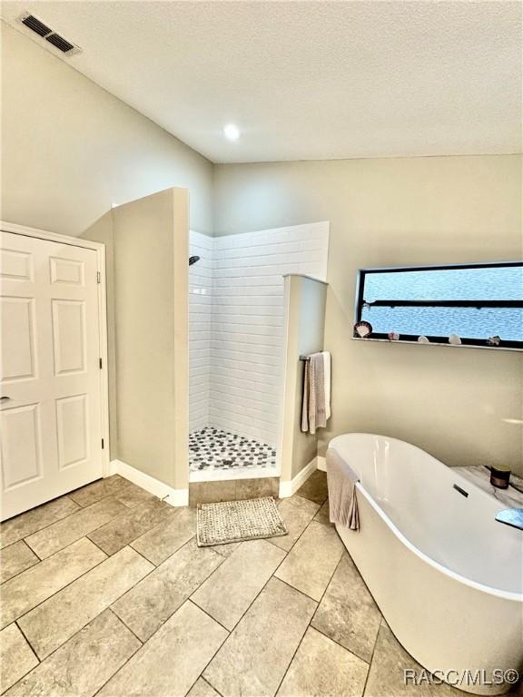 bathroom featuring shower with separate bathtub