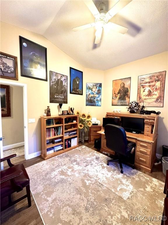 home office featuring ceiling fan, dark hardwood / wood-style floors, and lofted ceiling