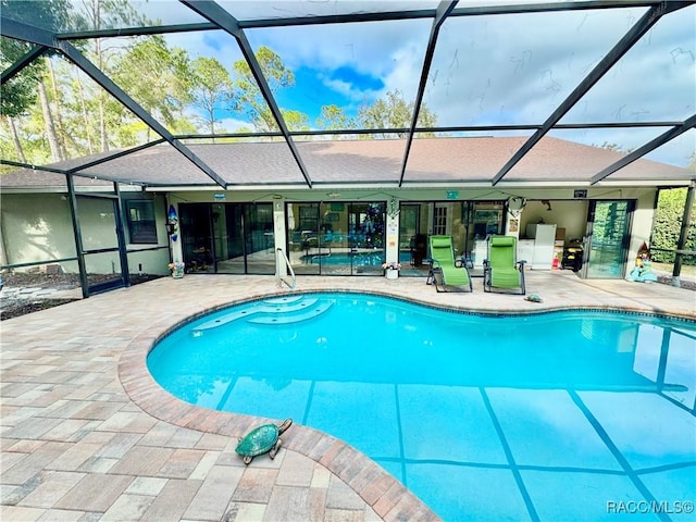 view of swimming pool featuring a lanai and a patio area